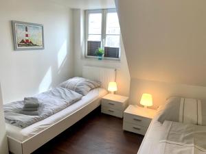 a small bedroom with a bed and two lamps at Ferienhaus RH "Strandkieker Middenmang" in Sankt Peter-Ording