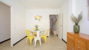 comedor con mesa y sillas amarillas en Empuriabrava Apartaments - nº7, en Empuriabrava