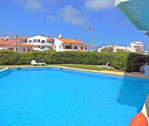 a large blue swimming pool with buildings in the background at Superb Apartment in Alvor in Alvor