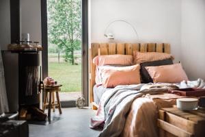 sypialnia z łóżkiem z poduszkami i oknem w obiekcie NATURE HOUSE Pszczyna w Pszczynie