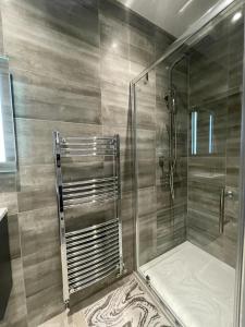 a shower with a glass door in a bathroom at Star London Finchley Road 3-Bed Retreat in London