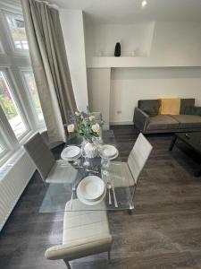 ein Wohnzimmer mit einem Tisch, Stühlen und einem Sofa in der Unterkunft Star London Finchley Road 3-Bed Retreat in London