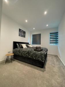 ein Schlafzimmer mit einem großen Bett und einem Tisch in der Unterkunft Star London Finchley Road 3-Bed Retreat in London