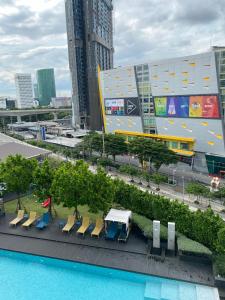 uma vista para um edifício com cadeiras e uma piscina em The Quarter Ladprao by UHG em Bangkok