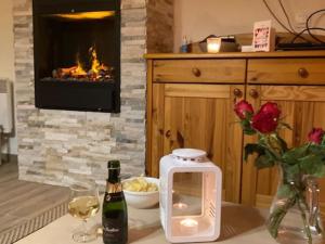 une table avec une bouteille de vin et une cheminée dans l'établissement Appartement cosy proche commerces, animaux bienvenus, parking - FR-1-464-160, à Pralognan-la-Vanoise 9 autres photos