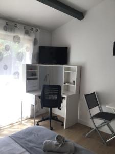 a bedroom with a desk with a computer and a chair at Studio L Oustaou in Marseille