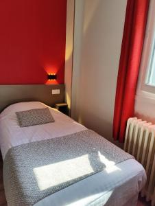 a bedroom with a bed and a red wall at Hotel Des Lices - Angers in Angers