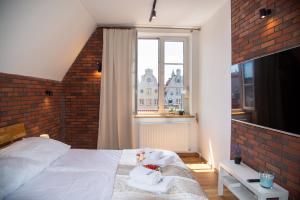 a bedroom with a bed with a brick wall at Maya's Flats & Resorts 47 - Dluga 18/19 in Gdańsk