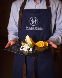 un hombre sosteniendo un plato con comida en él en Brudhäll Hotel & Restaurant en Kökar
