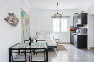 a living room with a table and a kitchen at Aegean style, city center studio next to Acropolis in Athens
