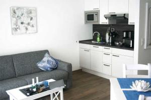 ein Wohnzimmer mit Couch und Küche in der Unterkunft Haus Meeresblick - Ferienwohnung Am Strand (Ref. 128682u2) in Baabe