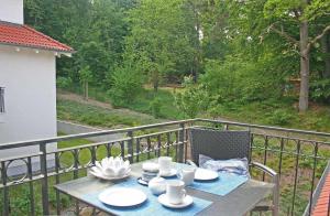 einen Tisch mit Tellern und Tassen auf einem Balkon in der Unterkunft Haus Meeresblick - Ferienwohnung Am Strand (Ref. 128682u2) in Baabe