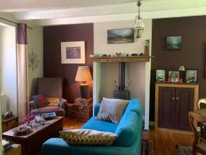 a living room with a blue couch and a table at Vingt Vieux Bourg in Rochefort-en-Terre