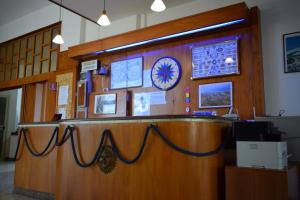 a lobby with a wooden counter with a blue rope at Hotel Oleandro in Cassano Jonio