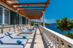 a row of lounge chairs on a balcony overlooking the water at Villa Orabelle in Dubrovnik