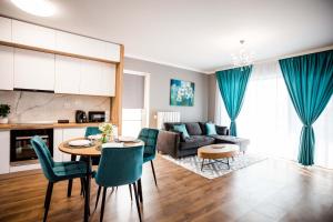 una cucina e un soggiorno con tavolo e sedie di Mon Jardin Apartment a Cluj-Napoca