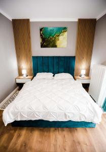una camera da letto con un grande letto con due comodini di Mon Jardin Apartment a Cluj-Napoca