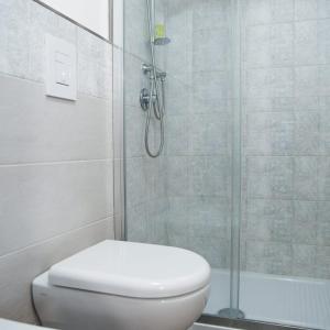 La salle de bains blanche est pourvue d'une douche et de toilettes. dans l'établissement A Villeggiatura, à Scilla