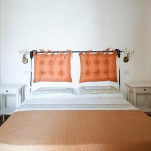 - un lit avec des oreillers orange dans l'établissement A Villeggiatura, à Scilla