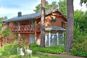 una casa di tronchi con terrazza e alberi di Green Gile Villa in Druskininkai Center a Druskininkai