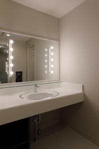 La salle de bains est pourvue d'un lavabo et d'un grand miroir. dans l'établissement ホテルバースデー岐阜西店 HOTEL Birthday GifuWest, à Gifu