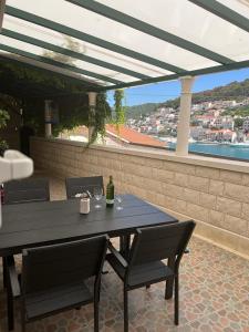 a table with two chairs and a bottle of wine at Apartment Lea in Pučišća