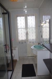 ein Bad mit einem Waschbecken, einem WC und Fenstern in der Unterkunft Louberne in Casteljaloux