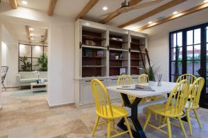 a dining room with a table and yellow chairs at Kseynasa Suites in Nikiti