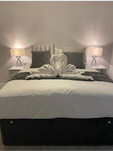 una camera con un grande letto con una scultura di cigno di Mnitri apartment a Luton