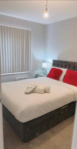 una camera da letto con un grande letto con cuscini rossi di Mnitri apartment a Luton