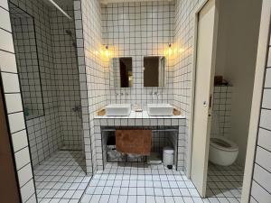 Baño de azulejos blancos con 2 lavabos y aseo en Appartement de maître T3 80m2 en plein centre., en Ajaccio