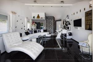 a living room with a white couch and chairs at Apartment OM in Povlja