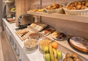a buffet line with different types of bread and pastries at B&B HOTEL Barcelona Sant Cugat in Sant Cugat del Vallès +32 photos