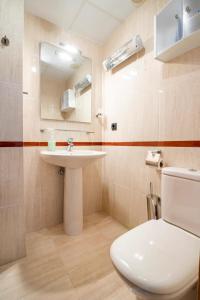 a bathroom with a white toilet and a sink at Apartamento frente al mar in Benicarló