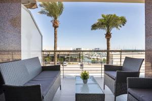 eine Terrasse mit 2 Palmen und einem Tisch in der Unterkunft Apartamento frente al mar in Benicarló