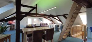 ein Wohnzimmer mit einem Holztisch und einer Leiter in der Unterkunft zentrumsnahes Wohnen in der Alten Schule am See in Schwerin