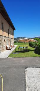 una mesa de picnic y bancos junto a un edificio en Palacio Marqués Vega de Anzo - Villa de campo sXVII, en Siero