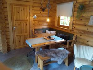 a dining room in a log cabin with a table and chairs at De Stamper - De Wije Werelt in Otterlo