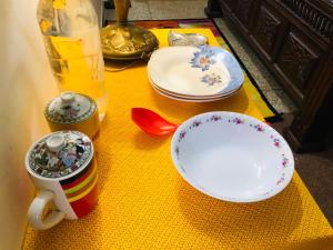 una mesa con platos y tazas en una mesa amarilla en Al-Noor Cottage en Rawalpindi