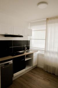 a white kitchen with a sink and a window at Belle appartement lumineux -Tram au pied de l'immeuble - in Hérouville-Saint-Clair