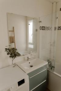 a white bathroom with a sink and a mirror at Belle appartement lumineux -Tram au pied de l'immeuble - in Hérouville-Saint-Clair