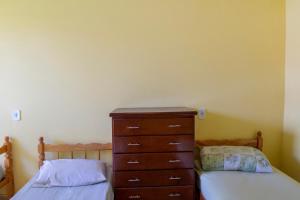 1 dormitorio con 2 camas individuales y vestidor en OYO Pousada Simone, en Itaboraí