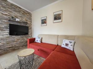 a living room with a red couch and a brick wall at Holiday Home Duje in Iž Mali