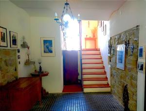 un pasillo con una puerta roja y escaleras en una casa en B&B La Quercia del Cilento, en Rocca Cilento