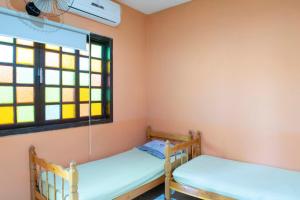 two bunk beds in a room with a window at OYO Pousada Simone in Itaboraí