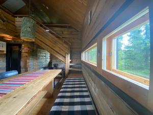 a bench in a cabin with a window at Loma-asunto tunturimaisemassa in Ylikyro