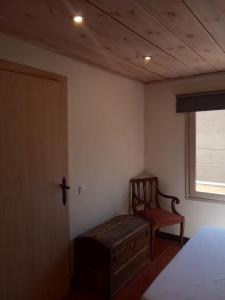 um quarto com uma cama, uma cadeira e uma janela em The Almond Tree em Torre del Compte