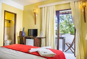 a bedroom with a bed and a television and a balcony at Milkyway Hotel in Jericoacoara