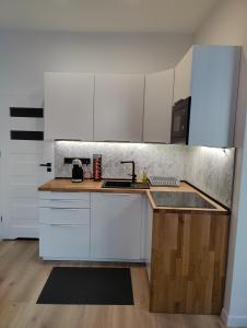 a kitchen with white cabinets and a sink at Apartament Szczecin in Szczecin