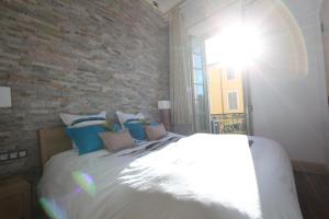a bedroom with a large white bed with a brick wall at Nice Massena in Nice